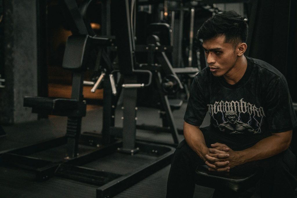 A man sitting on a bench in a gym