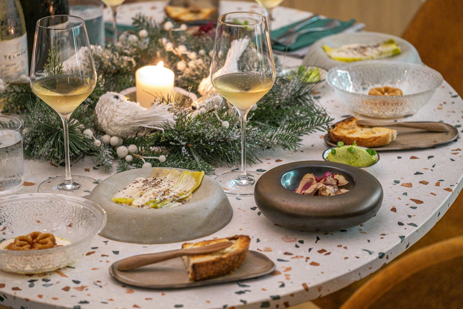 A table topped with plates of food and glasses of wine